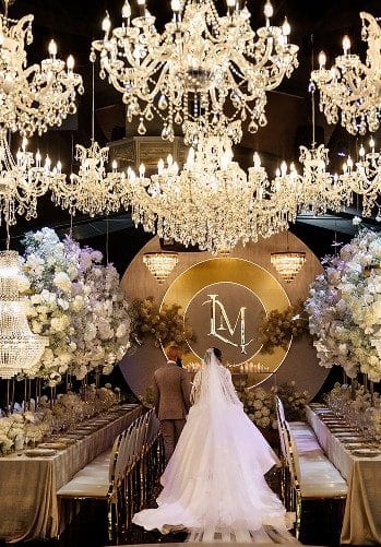 Bride and groom beneath crystal chandeliers