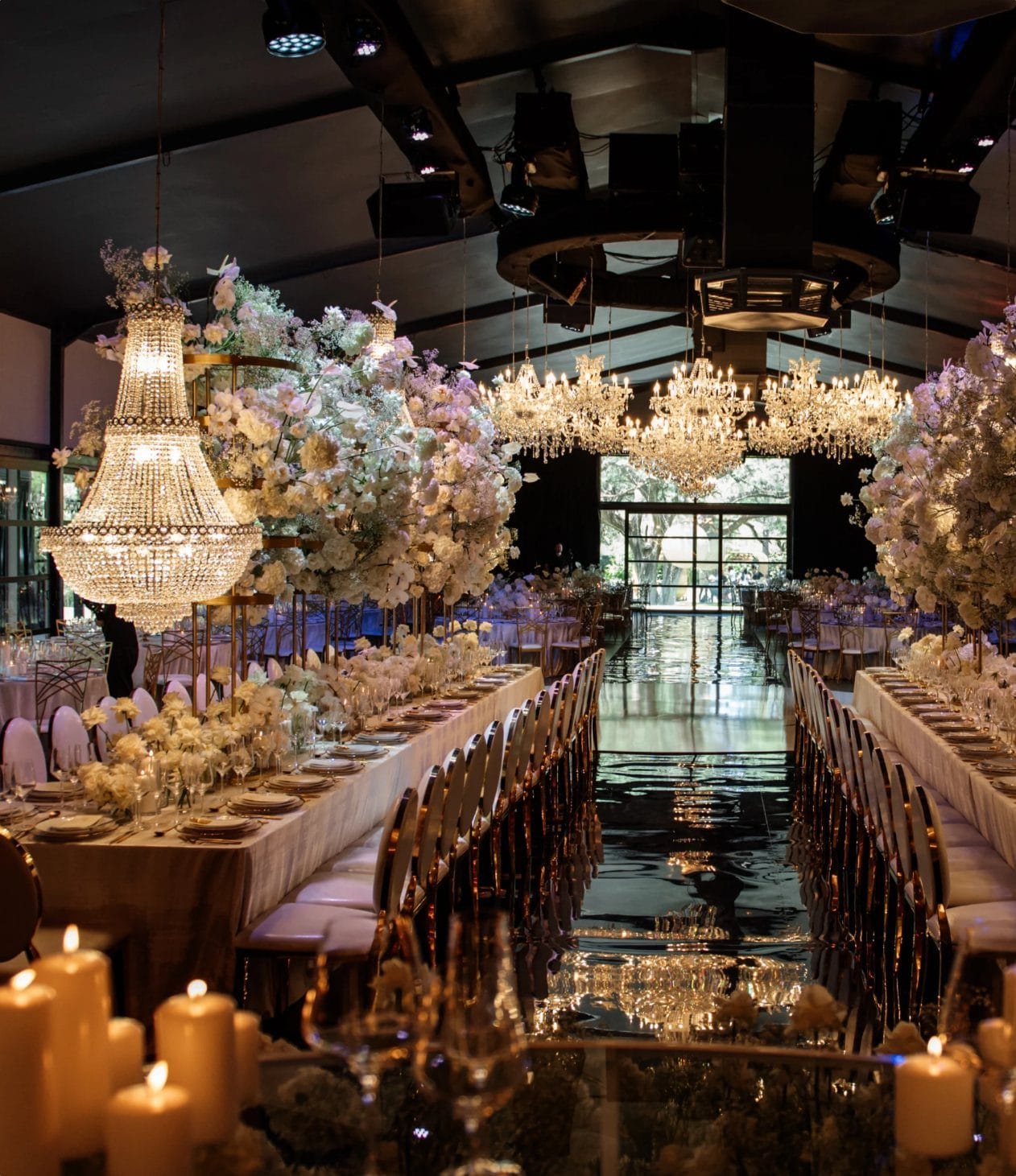 Candlelit wedding reception beneath crystal chandeliers