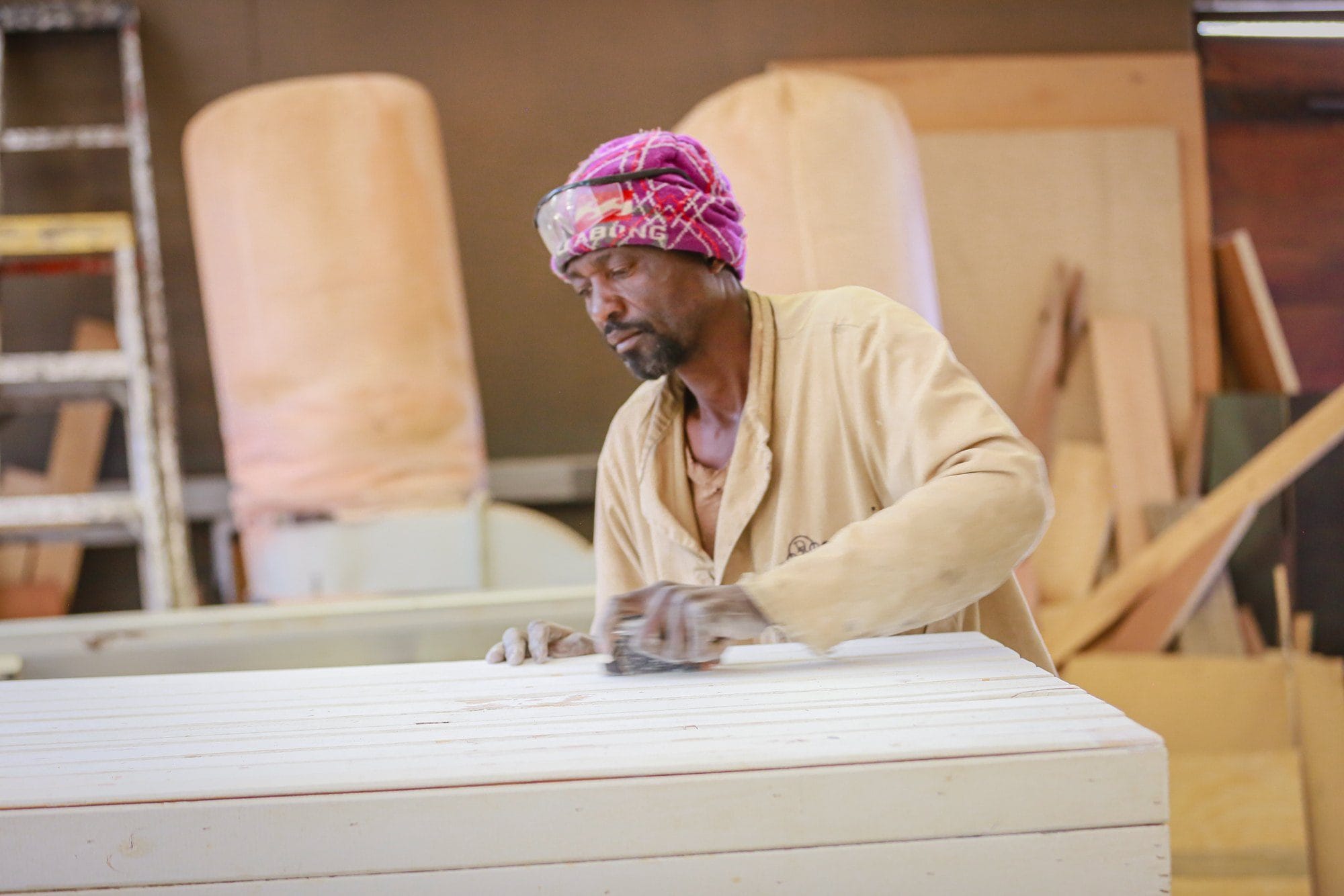 Craftsman sanding handmade furniture in the Droombos workshop
