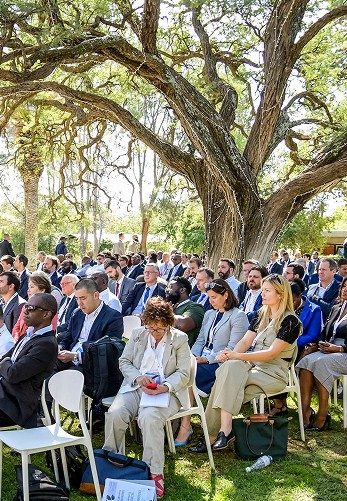 Delegates gathered beneath the Camelthorn trees