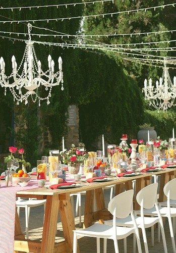 Garden table beneath hanging chandeliers
