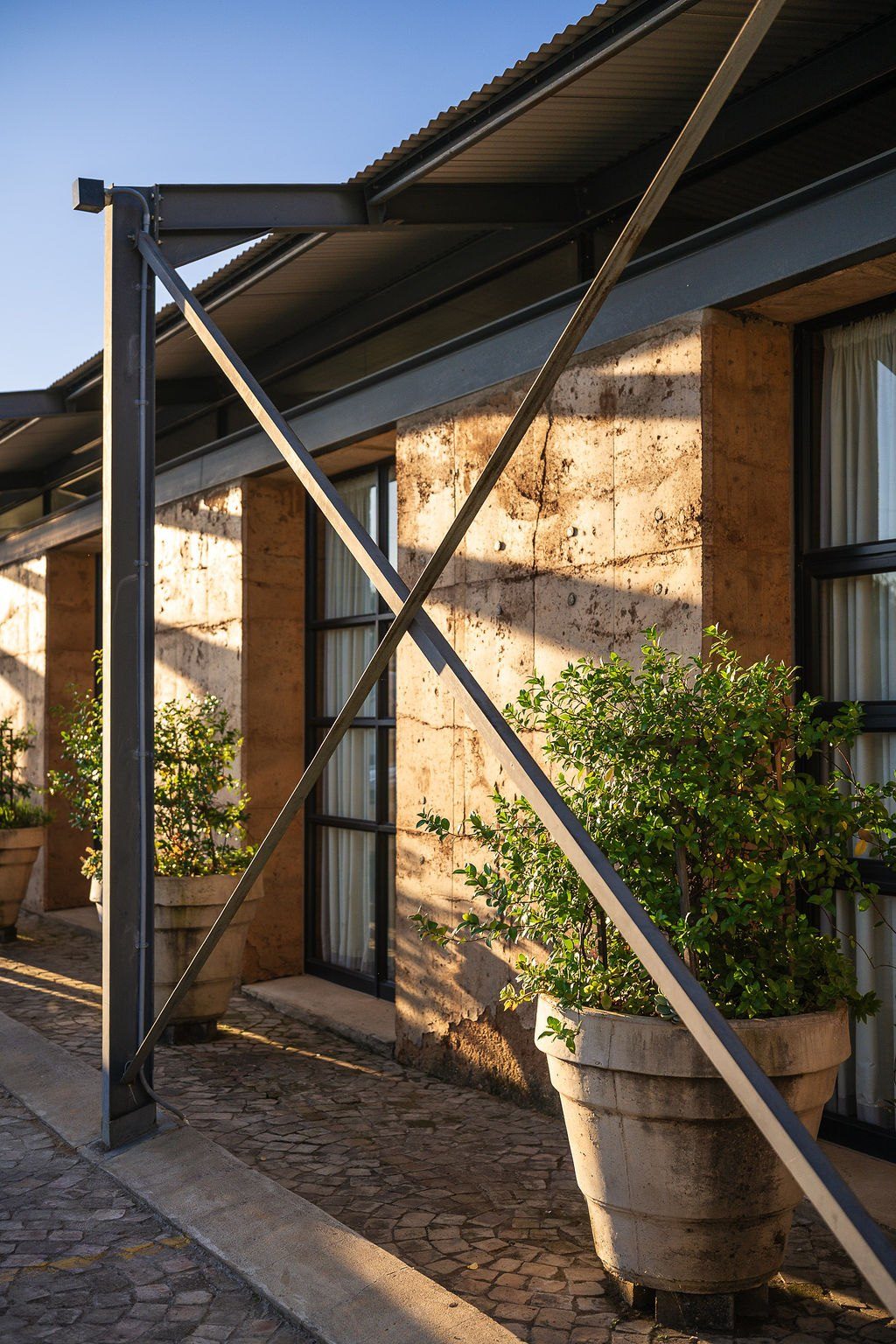 Rammed earth walls beneath a steel pergola
